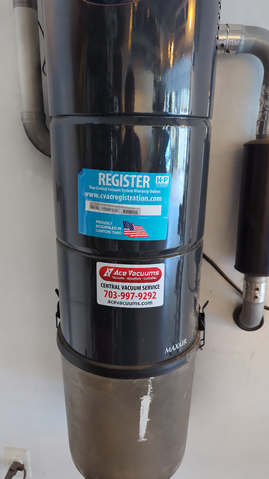 Central vacuum power unit with an AceVacuums service label and connected exhaust pipe at AceVacuums