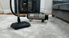 Metrovac PROFESSIONAL EVOLUTION Full-Size Canister Vacuum – Part# 104-578567 – canister and powerhead on carpet beside sofa