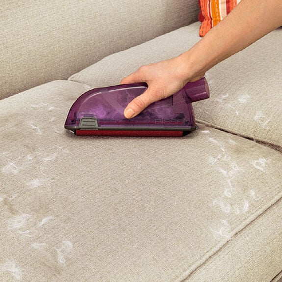 BISSELL Pet Hair Eraser Upholstery Tool 1604117 side close-up gathering hair on a couch without a hose