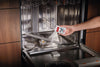 Miele GP CL WG 2001 P IntenseClean 7 oz (200 g) appliance cleaner — adding cleaning powder to a dishwasher