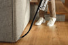 Miele HX-FCT 20 Duoflex cleaning kit — cleaning beside a sofa with the hose attachment