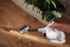 Miele Duoflex HX1 Extra Cordless Vacuum Brilliant White — picking up scattered debris around furniture