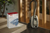 Miele GN HyClean Air 4 vacuum bags — dust bag packaging beside a canister vacuum