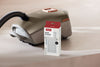 Miele SF-HA 50-2 XL pack HEPA AirClean filter — filter packaging beside a canister vacuum