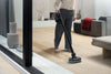 Miele HX-AT 10 Triflex AquaTwister — cleaning a hard floor beside patio doors