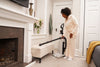 Riccar Clean Air Premium Pet Upright Vacuum - R27P – extended wand cleaning beside fireplace