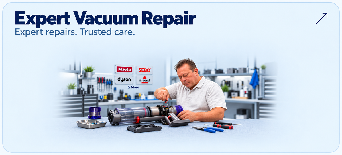 Expert vacuum repair at Ace Vacuums — Joel servicing a cordless vacuum in a workshop with Miele, SEBO, Dyson and BISSELL signs.