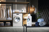 Miele Liquid Detergent UltraSoft Fabric Softener 11987230, beside towels in a laundry room