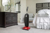 Red Riccar R10P.2 SupraLite Premium upright vacuum in a bedroom. Available at AceVacuums.