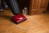 Red Riccar R10P.2 SupraLite Premium vacuum cleaning debris on a wood floor. Available at AceVacuums.