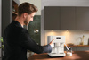 Miele CM 6160 MilkPerfection White Coffee Machine #11648170 – person using coffee machine in a kitchen